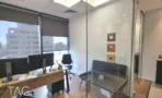 חדר עבודה עם עמדות מחשב מאחורי מחיצת זכוכית