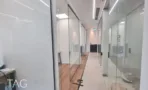 מסדרון פנימי עם מחיצות זכוכית ורצפת פרקט
