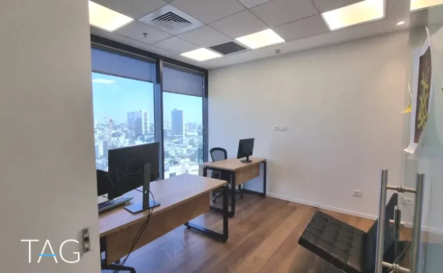 חדר עבודה עם שולחן ונוף העיר מהחלון
