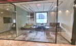חדר עבודה מאחורי מחיצות זכוכית במשרד להשכרה בבית עוז ברמת גן, עמדות מחשב ושטיח מודולרי - תג נכסים