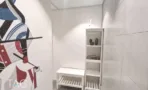 פינת כניסה במשרד להשכרה בבית עוז ברמת גן, ציור קיר צבעוני, ספסל לבן וכוננית פתוחה - תג נכסים