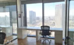 עמדת עבודה לבנה מול חלון עם נוף למגדלי תל אביב