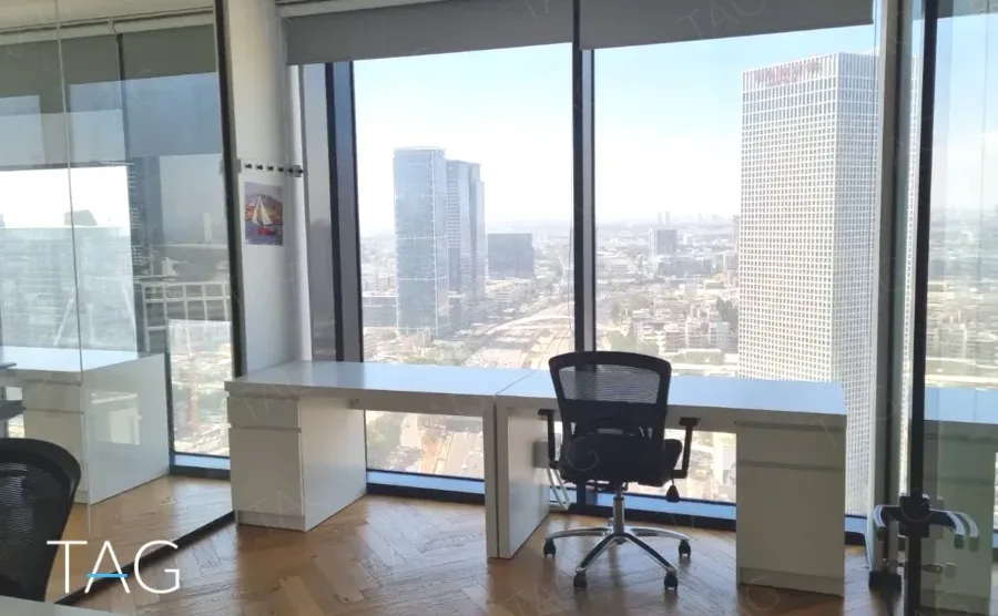 עמדת עבודה לבנה מול חלון עם נוף למגדלי תל אביב