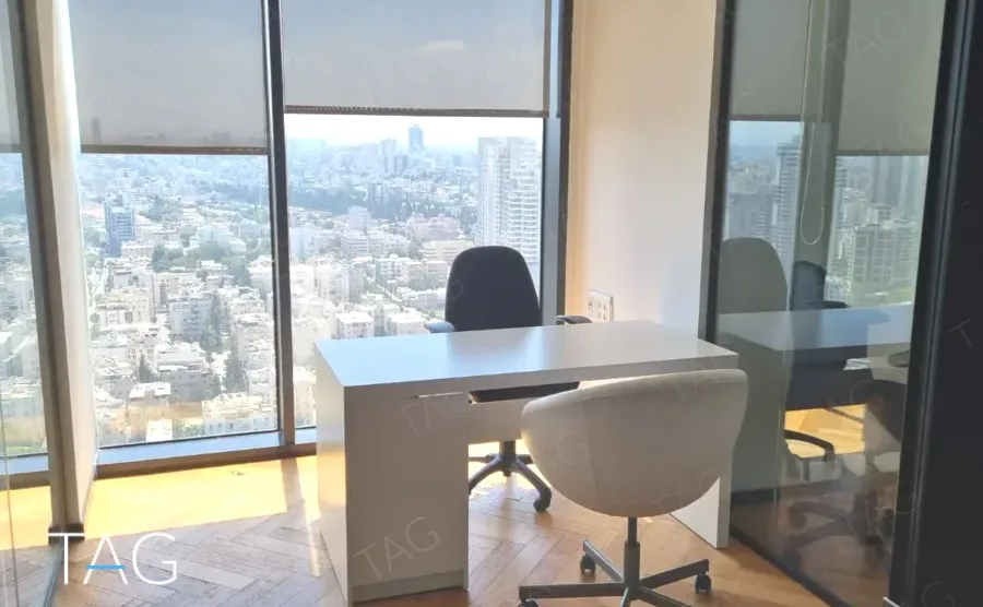 עמדת עבודה פינתית עם כורסה לבנה ונוף עירוני