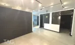 אזור כניסה עם חיפוי כהה ודלפק לבן במשרד 132 מ״ר במגדל אקרו