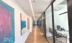 משרד להשכרה 450 מ״ר במגדלי אלון, מסדרון מואר עם תמונות אמנות וחדרי זכוכית