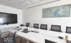משרד להשכרה 450 מ״ר במגדלי אלון, חדר ישיבות עם שולחן לבן ארוך, כיסאות ומסך