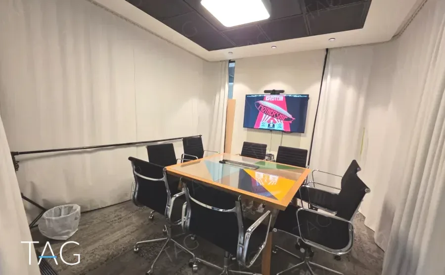 חדר ישיבות עם שולחן עץ, כיסאות שחורים, מסך על הקיר ווילון לבן על החלון - משרד 890 מר, אריה שנקר מרכז גב ים הרצליה - תג נכסים