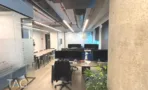 אופן ספייס עם עמוד בטון ושולחנות עבודה ארוכים במשרד 168 מ״ר במגדל אקרו
