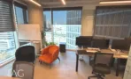 אזור עבודה עם לוח מחיק וכורסה כתומה מול חלון במשרד 168 מ״ר במגדל אקרו