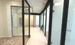 מסדרון עם חדרי זכוכית ורצפת פרקט במשרד במגדל אייקון