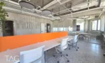 עמדות עבודה עם מחיצה כתומה ופינת אוכל במשרד 600 מר במגדל LYN