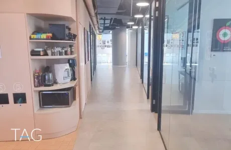 מסדרון עם חדרים מזוגגים ופינת מטבחון במשרד 741 מ"ר בעזריאלי שרונה