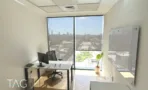 חדר עבודה עם שולחן, לוח מחיק ונוף העיר מהחלון