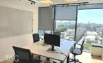 חדר עבודה עם עמדות מחשב, לוח מחיק וחלון לנוף