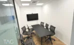 חדר ישיבות עם שולחן כהה, מסך ומחיצת זכוכית