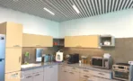 מטבחון עובדים במשרד להשכרה במגדל אדגר 360C - משטח גרניט, ארונות בגוון חול, מכונת קפה ומיקרוגל - תג נכסים