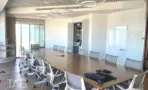 חדר ישיבות במשרד להשכרה במגדל אדגר 360C - שולחן ארוך לכ-16 מקומות, תאורה מעגליות תלויה ולוח כתיבה זכוכית - תג נכסים