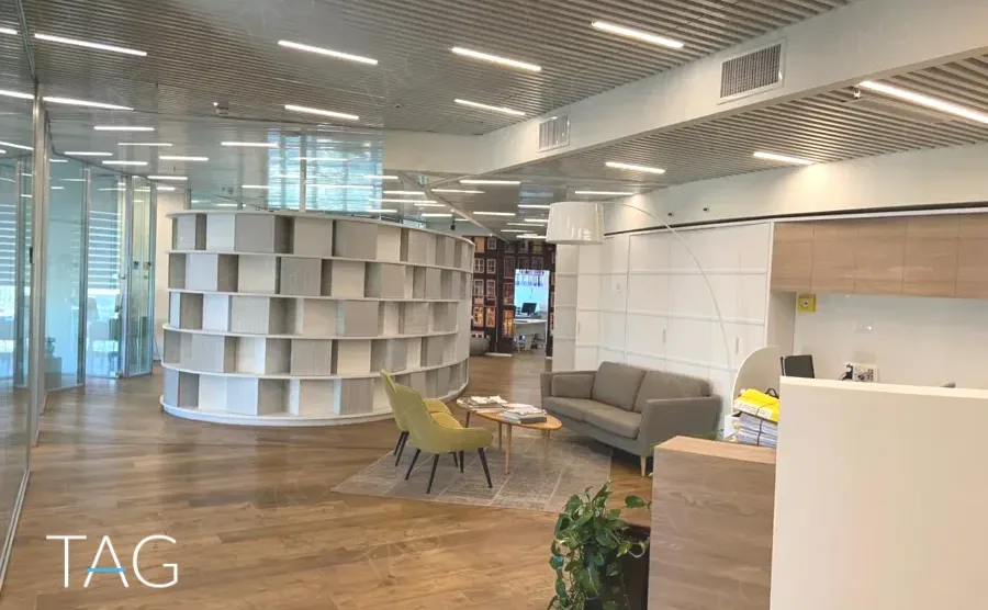 חלל הכניסה במשרד להשכרה במגדל אדגר 360C - יחידת מדפים מעוגלת, רצפת פרקט ותקרת רפפות מתכת - תג נכסים
