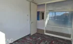 חדר עם דלת לבנה ומחיצת זכוכית, קיר כחול בחלל הסמוך ושטיח מודולרי מודפס - משרד 918 מר, אריה שנקר מרכז גב ים הרצליה - תג נכסים