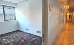 חדר ריק עם חלון ומדרון מסדרון מזוגג עם ריצוף עץ בהמשך - משרד 918 מר, אריה שנקר מרכז גב ים הרצליה - תג נכסים