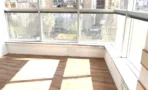 משרד להשכרה בבית פרינסס - חלל פינתי עם חלונות רציפים, אדן עץ ורצפת פרקט מוארת באור טבעי - תג נכסים