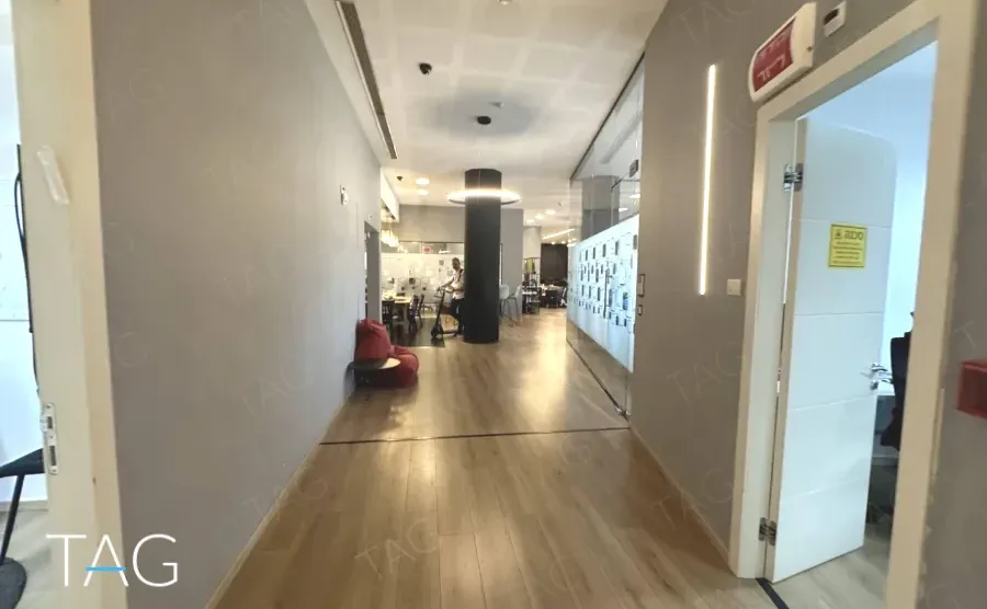 מסדרון עם פרקט אלון ודלת זכוכית לחדר עבודה במשרד להשכרה ליד רכבת השלום - תג נכסים