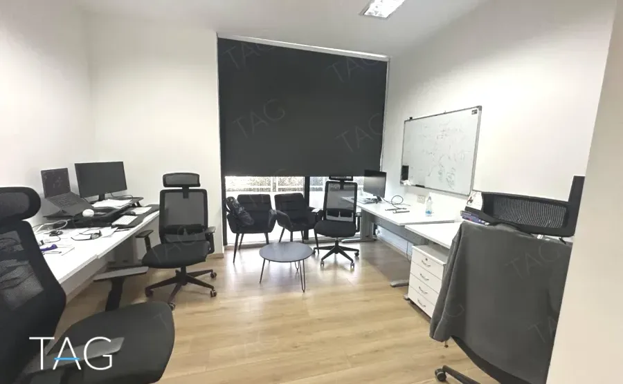 חדר ישיבות עם לוח מחיק ושולחנות עבודה במשרד להשכרה ליד רכבת השלום - תג נכסים