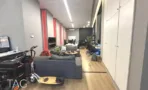 פינת ישיבה עם ספה וארונות אחסון לבנים במשרד להשכרה ליד רכבת השלום - תג נכסים