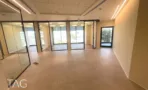חלל פתוח עם חדרי זכוכית וריצוף אריחים במשרד במגדל אייקון