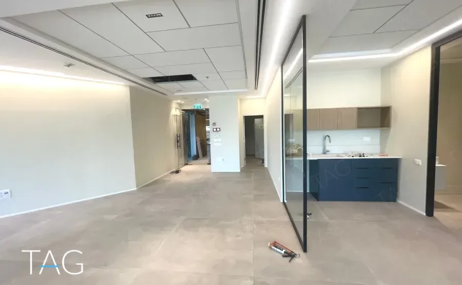 חלל פתוח עם מטבחון וריצוף אריחים במשרד במגדל אייקון