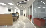 מעבר עם מחיצות זכוכית ותאורה לינארית במשרד להשכרה ליד רכבת השלום - תג נכסים