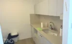 מטבח עם כיור ומשטח בז וארונות לבנים במשרד במגדל שלום מאיר
