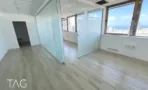 חלל משרד עם מחיצות זכוכית וחלונות פינתיים אל העיר במגדל שלום מאיר