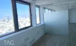 חדר עם חלון גדול אל נוף העיר ופרקט בהיר במשרד במגדל שלום מאיר