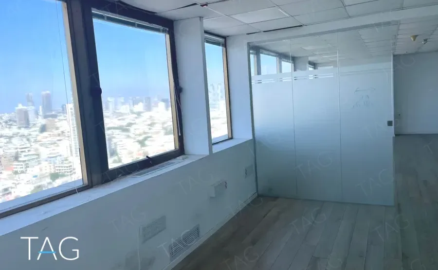 חדר עם חלון גדול אל נוף העיר ופרקט בהיר במשרד במגדל שלום מאיר
