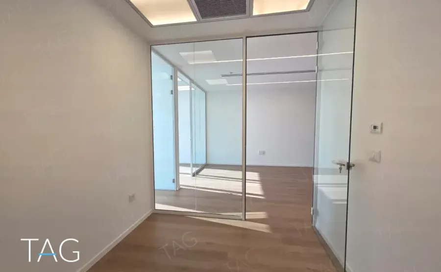 חדר מזוגג בACRO BUSINESS CAMPUS עם פרקט עץ, תקרה שקועה ותאורה עקיפה - תג נכסים
