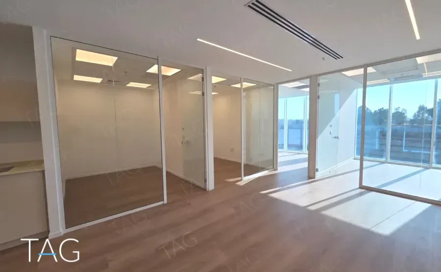 חלל משרדי בACRO BUSINESS CAMPUS עם מחיצות זכוכית, פרקט עץ ואור יום מלא - תג נכסים