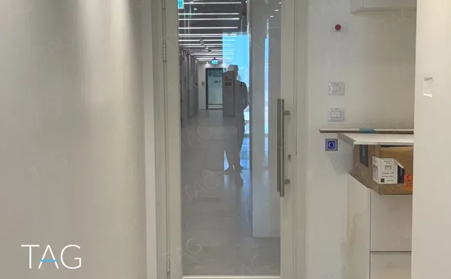 מבואת קומה בACRO BUSINESS CAMPUS עם דלת זכוכית ומסדרון מואר - תג נכסים