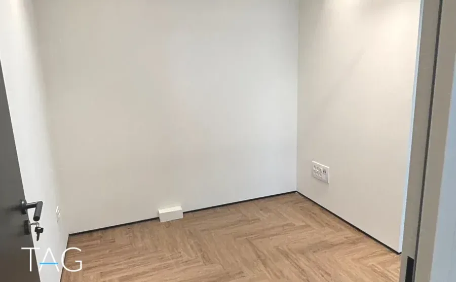 חדר משרד בACRO BUSINESS CAMPUS עם פרקט אדרה בגוון אגוז וקירות בהירים - תג נכסים