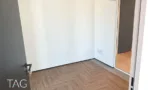 חדר בACRO BUSINESS CAMPUS עם פרקט אדרה, דלת שחורה ופתח למסדרון - תג נכסים