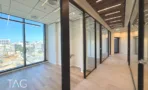 חלל עבודה פתוח עם תקרת שלבי עץ וחדרי זכוכית במגדל אייקון
