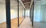 מסדרון עם חדרי זכוכית ותקרת עץ במשרד במגדל אייקון