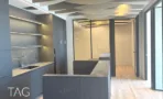 מטבח משרדי בACRO BUSINESS CAMPUS עם ארונות כהים, משטח אבן ותקרה מעוצבת - תג נכסים