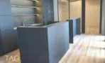מטבח משרדי בACRO BUSINESS CAMPUS עם ארונות כהים, כיור ומשטח אבן - תג נכסים