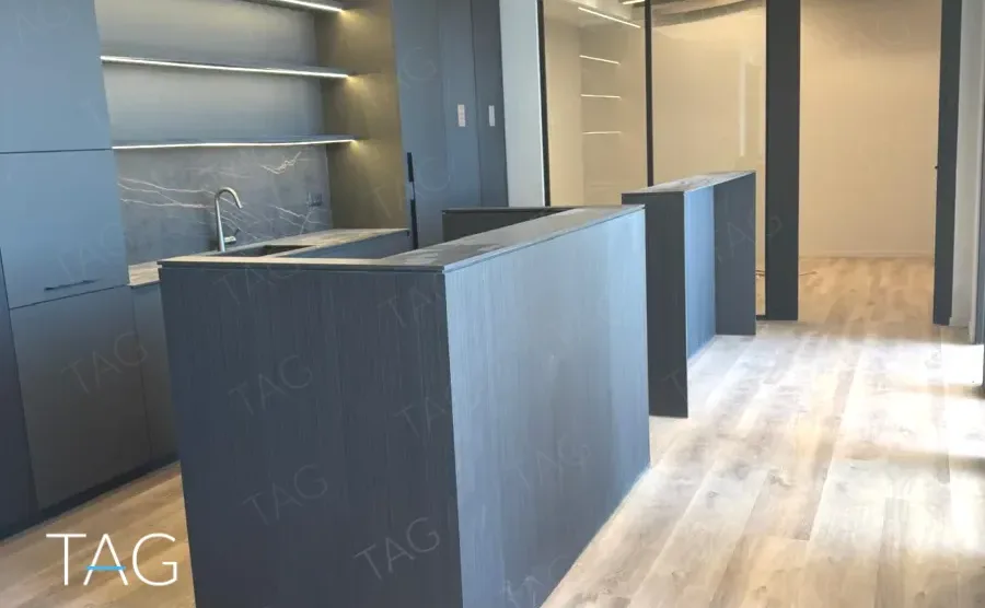 מטבח משרדי בACRO BUSINESS CAMPUS עם ארונות כהים, כיור ומשטח אבן - תג נכסים