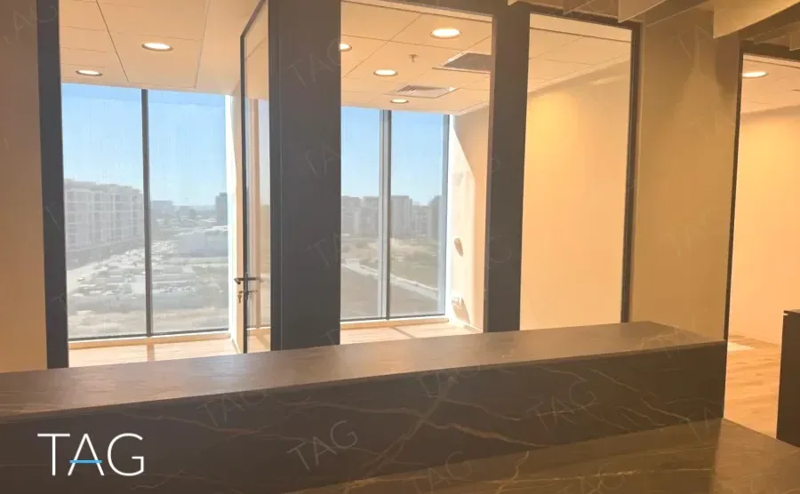 דלפק קבלה בACRO BUSINESS CAMPUS עם משטח אבן כהה וחיפוי עץ - תג נכסים