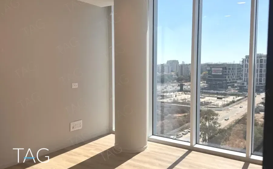 משרד פינתי בACRO BUSINESS CAMPUS עם עמודי בטון, חזית זכוכית ופרקט עץ - תג נכסים