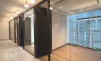 מסדרון משרדים בACRO BUSINESS CAMPUS עם מחיצות זכוכית, פרקט ותאורה תלויה - תג נכסים