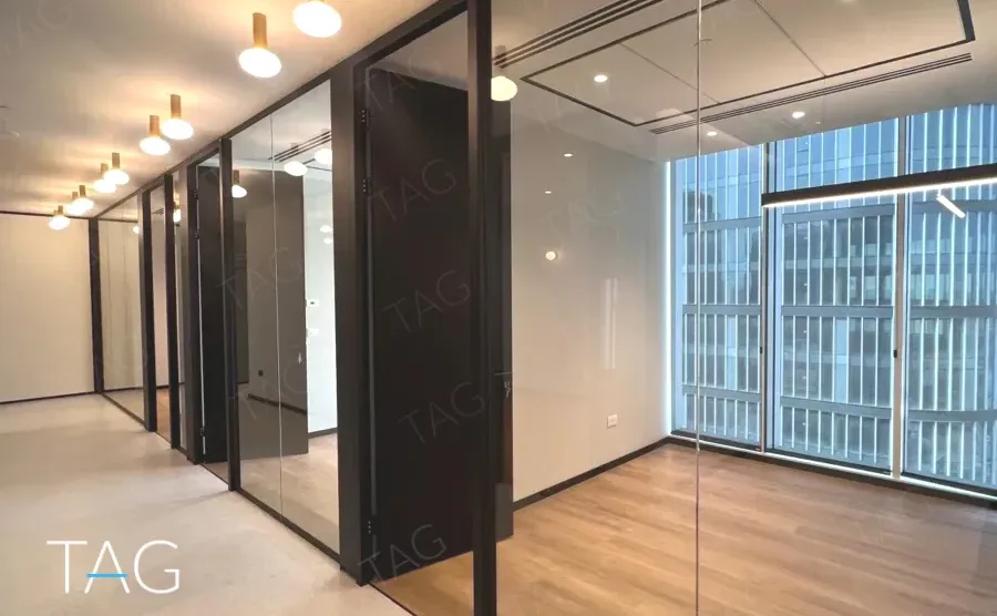 מסדרון משרדים בACRO BUSINESS CAMPUS עם מחיצות זכוכית, פרקט ותאורה תלויה - תג נכסים